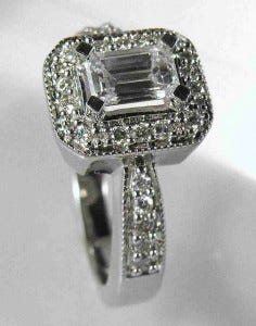 Photo by derrico_jewelry (Flickr): This four-prong emerald-cut diamond has a halo-like setting around it.