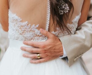 men's gold wedding band on groom with bride