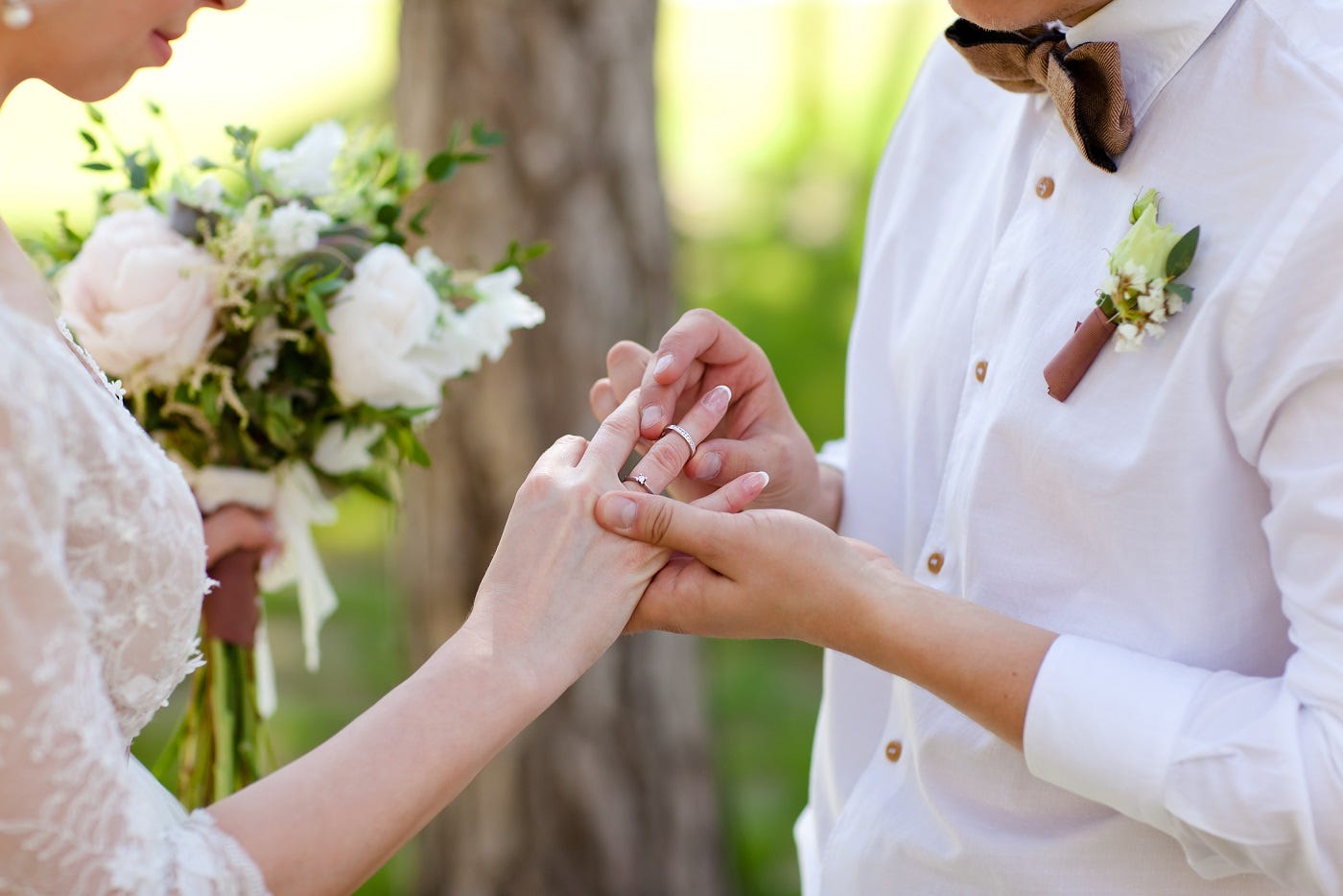Groom placing women's engagement ring on finger